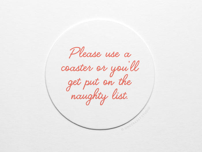 The Naughty List Coaster Set by Onderkast Studio features round white letterpress coasters with red cursive text: Please use a coaster or you’ll get put on the naughty list. Handmade on durable pulp board.