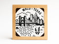 The Waco Texas Skyline Letterpress Coaster Set by Onderkast Studio features black-and-white cityscape illustrations, including a bridge, river, buildings, silos, and plants with WACO • TEXAS at the top, packaged in a cardboard box.